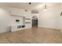 A spacious living room featuring light tile floors, modern built-ins, and neutral wall paint at 1063 W Vaughn St, Tempe, AZ 85283