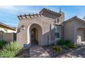 Exterior shot featuring an arched entry with a brick walkway and flower bed with yellow flowers at 1123 W Thunderhill Dr, Phoenix, AZ 85045