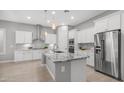 Spacious kitchen with a large island, granite countertops, stainless steel appliances, and white cabinets at 1123 W Thunderhill Dr, Phoenix, AZ 85045