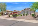 Inviting single-story home with manicured desert landscaping and vibrant red garage door at 11306 E Rembrandt Ave, Mesa, AZ 85212