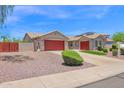 Attractive single-story home with a red garage door, desert landscaping, and solar panels at 11306 E Rembrandt Ave, Mesa, AZ 85212