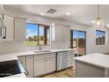 Bright kitchen features white cabinets, stainless steel appliances, and views to the backyard at 1236 S Boulder St # C, Gilbert, AZ 85296