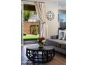 Cozy living room with elegant curtains, a large clock, and a view of the backyard at 1255 N Arizona Ave # 1013, Chandler, AZ 85225