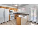 An open-concept kitchen with wood cabinets, granite counters, and modern appliances at 12602 N 38Th Ave, Phoenix, AZ 85029