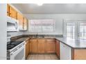Bright kitchen featuring wood cabinets, a stainless steel sink, granite countertops, and modern appliances at 12602 N 38Th Ave, Phoenix, AZ 85029