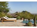 Inviting pool area features lounge chairs and stunning mountain views, creating a relaxing outdoor oasis at 12887 N 135 St, Scottsdale, AZ 85259