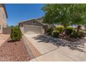 Beautiful home with a two-car garage, mature trees, and an inviting driveway and walkway at 1628 E Aspen Ave, Buckeye, AZ 85326
