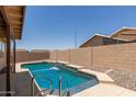 A private backyard pool features a beautiful waterfall and a spacious tanning deck at 16288 W Hadley St, Goodyear, AZ 85338