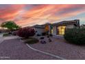 Inviting home with desert landscaping, arched entry, and a warm ambiance at sunset at 17812 W Primrose W Ln, Surprise, AZ 85374