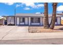 Charming single-story home with a white exterior and blue trim and a large palm tree in the front yard at 2207 W Bentrup St, Chandler, AZ 85224