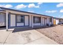 Inviting single-story home with a white exterior and blue trim, a covered driveway and well-maintained landscaping at 2207 W Bentrup St, Chandler, AZ 85224