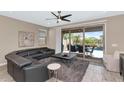Comfortable living room with a ceiling fan, a leather sectional, and sliding glass doors to the patio at 22353 N 99Th Ln, Peoria, AZ 85383