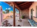 A covered courtyard features a stone fireplace, seating area, and lush landscaping at 2843 E Captain Dreyfus Ave, Phoenix, AZ 85032