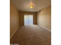 The carpeted living room has a sliding door and natural light at 3434 E Baseline Rd # 204, Phoenix, AZ 85042
