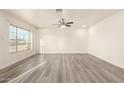 Bright and airy living room features stylish gray flooring, neutral walls, and a contemporary ceiling fan at 3513 W Maryland Ave, Phoenix, AZ 85019