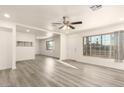 Inviting living room with modern flooring, fresh white paint, large windows, and a contemporary ceiling fan at 3513 W Maryland Ave, Phoenix, AZ 85019