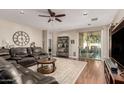Inviting living room featuring a leather sofa, ceiling fan, and sliding glass door at 3532 W Mesquite Ave, San Tan Valley, AZ 85144