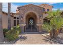 Elegant front entryway with gated access, stone archway, and lush landscaping at 4327 E Capricorn Pl, Chandler, AZ 85249