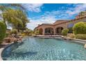 Resort-style pool with a built-in spa, rock features, and covered patio at 4327 E Capricorn Pl, Chandler, AZ 85249