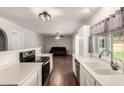Modern kitchen with stainless steel appliances, white cabinets and views into the living room and backyard at 4419 W Vogel Ave, Glendale, AZ 85302