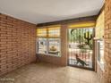Cozy covered patio with brick walls and decorative ironwork offering a private and shaded outdoor retreat at 4509 E Joan De Arc Ave, Phoenix, AZ 85032