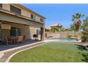 Outdoor oasis featuring a refreshing pool, putting green, and cozy patio perfect for relaxation and entertainment at 46141 W Rainbow Dr, Maricopa, AZ 85139