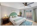 Cozy bedroom featuring neutral walls, ceiling fan, ensuite, and sliding glass doors to yard at 5343 W Vogel Ave, Glendale, AZ 85302