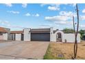 Single-story home with a spacious driveway, two-car garage, and decorative gate at 5343 W Vogel Ave, Glendale, AZ 85302