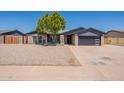 Charming single-story home with xeriscaped yard, complemented by mature tree and modern garage door at 6719 S Hardy Dr, Tempe, AZ 85283