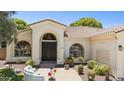 Inviting front entry with custom wood door, arched windows and manicured landscaping with mature trees at 7032 N 2Nd Ave, Phoenix, AZ 85021
