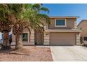 Two-story home with desert landscaping, attached two-car garage, and desert landscaping with palm trees at 8939 W Villa Rita Dr, Peoria, AZ 85382