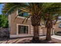 View of a two story home with desert landscaping, palm trees, and an attached two-car garage at 8939 W Villa Rita Dr, Peoria, AZ 85382