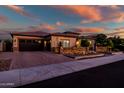 Charming single-story home featuring a tile roof, three-car garage, desert landscaping, and a paver driveway at 9255 W Los Gatos Dr, Peoria, AZ 85383
