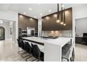 Modern kitchen with a large island, high-end appliances, sleek cabinetry, and counter seating at 9255 W Los Gatos Dr, Peoria, AZ 85383