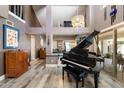 Bright living area featuring wood floors, a grand piano, high ceilings and modern decor at 10068 E San Salvador Dr, Scottsdale, AZ 85258