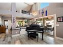 Open living space with high ceilings, wood floors, and a grand piano, perfect for entertaining at 10068 E San Salvador Dr, Scottsdale, AZ 85258