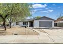 Charming single-story home with a gray roof, a gray garage door and xeriscaping at 1119 W Ellis Dr, Tempe, AZ 85282
