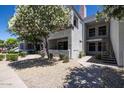 Condo exterior with a walkway, stairs to the second level, xeriscaping, and flowering trees at 11375 E Sahuaro Dr # 1055, Scottsdale, AZ 85259