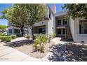 Exterior view of condo with well-maintained landscaping, a walkway, and stairs to the second level at 11375 E Sahuaro Dr # 1055, Scottsdale, AZ 85259