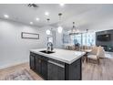 Stylish kitchen island with quartz countertop, black base, stainless steel appliances, and open layout to the living area at 120 E Rio Salado Pkwy # 101, Tempe, AZ 85281