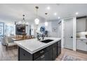 Open-concept kitchen featuring an island with a black base, quartz countertop, and pendant lighting, flowing into the living space at 120 E Rio Salado Pkwy # 101, Tempe, AZ 85281