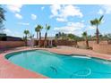Large backyard pool with red brick trim with lush landscaping and clear blue sky in the background at 1238 E Cambridge Ave, Phoenix, AZ 85006