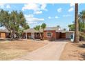 Inviting single-story red brick home featuring a covered carport and a spacious driveway at 1238 E Cambridge Ave, Phoenix, AZ 85006