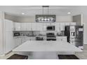 Newly remodeled kitchen features stainless appliances, a large island, and sleek white cabinets for a modern feel at 13050 N Breeze Way, Maricopa, AZ 85139