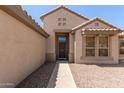 Inviting entryway featuring a secure screen door and neutral stucco, blending security and style at 15874 W Wildflower Dr, Surprise, AZ 85374