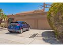 View of the three-car garage and driveway with a dark blue car parked in front of the property at 1751 W Mulberry Dr, Chandler, AZ 85286