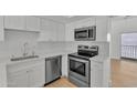 Modern kitchen featuring white cabinets, stainless steel appliances, and bright lighting at 220 N 22Nd Pl # 2036, Mesa, AZ 85213