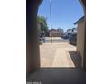 View from the arched porch showing a brick walkway to the driveway at 3844 N 88Th Ln, Phoenix, AZ 85037
