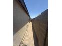 Narrow side yard with block wall and brick pathway at 3844 N 88Th Ln, Phoenix, AZ 85037