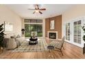 Bright living room featuring fireplace, large window, ceiling fan, wood flooring, and neutral tones at 4135 E Altadena Ave, Phoenix, AZ 85028